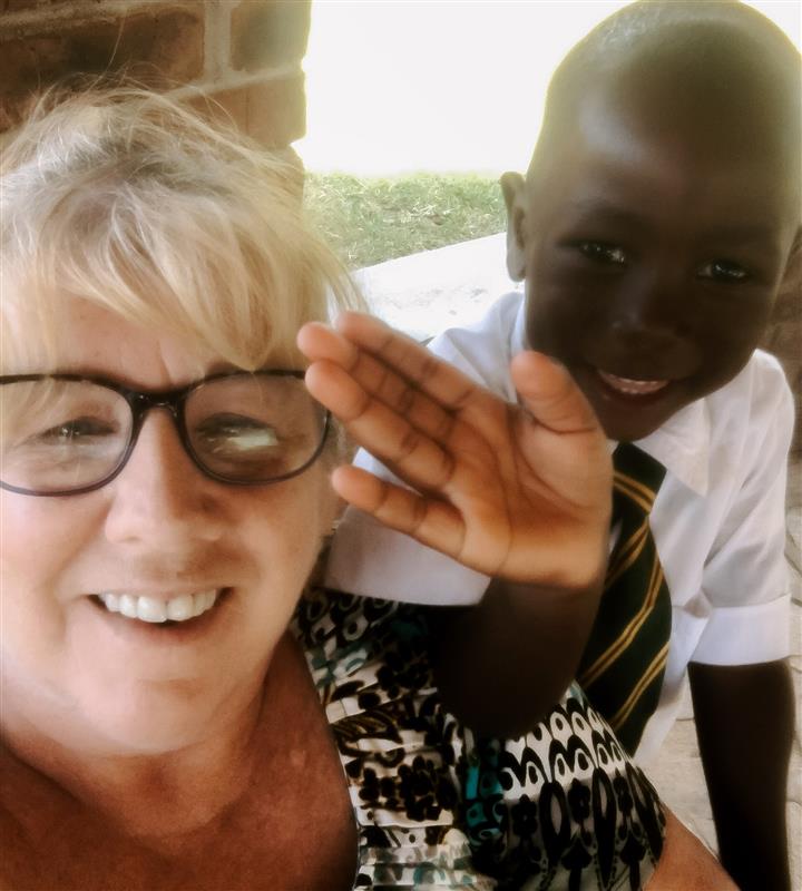 Jeanette smiling at camera with child.