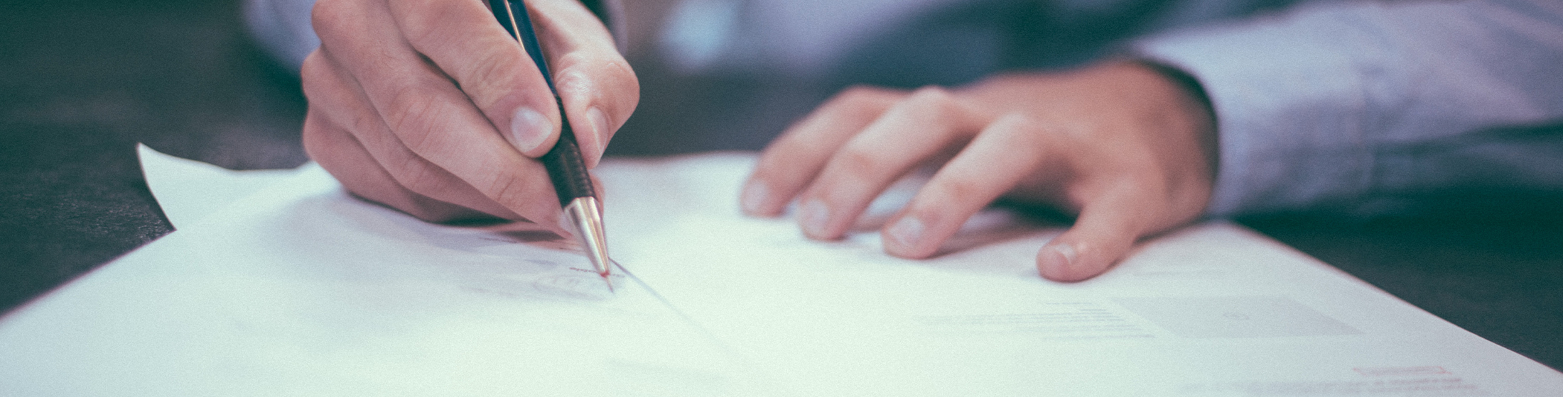 Photo banner by Scott Graham on Unsplash of a man signing a paper.
