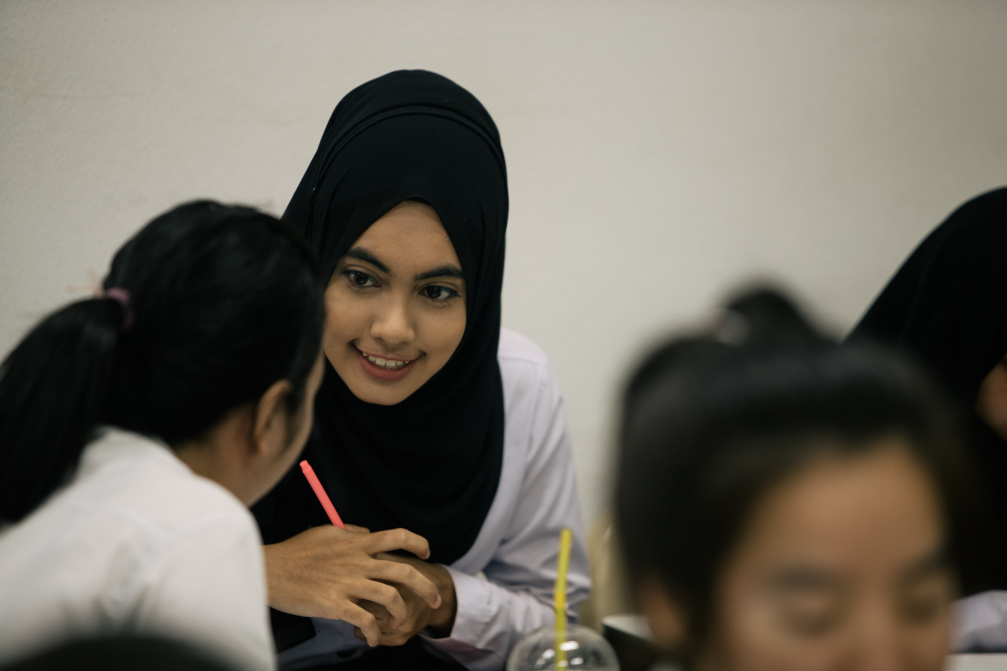 Photo of three girls talking while studying by Imagine Thailand