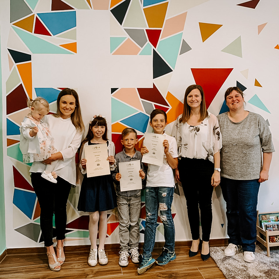 Kids standing in front of cross at Sunday school