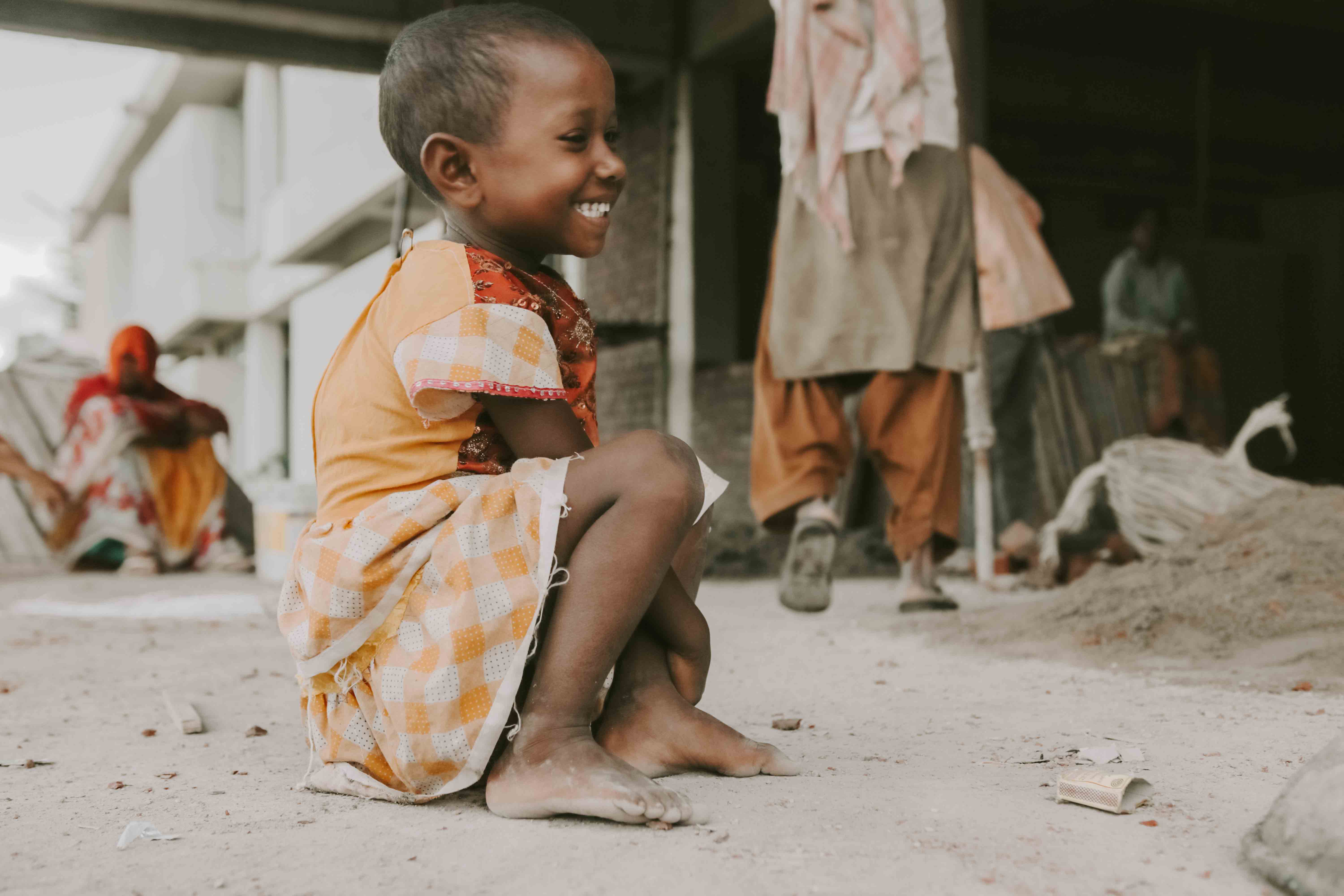 Photo of a young  child smiling while looking to the side.