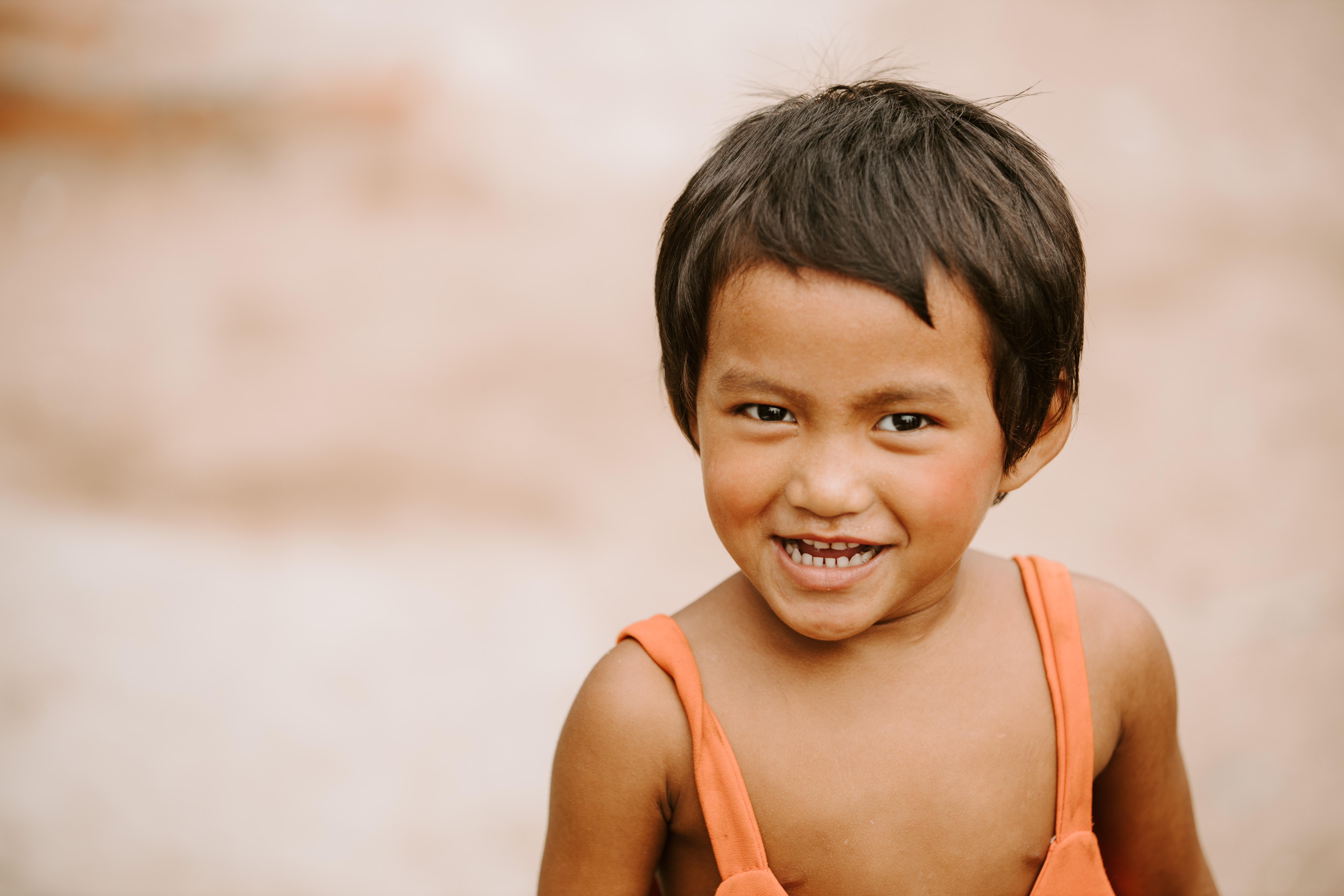 Photo of a little boy smiling at the camera from Cambodia