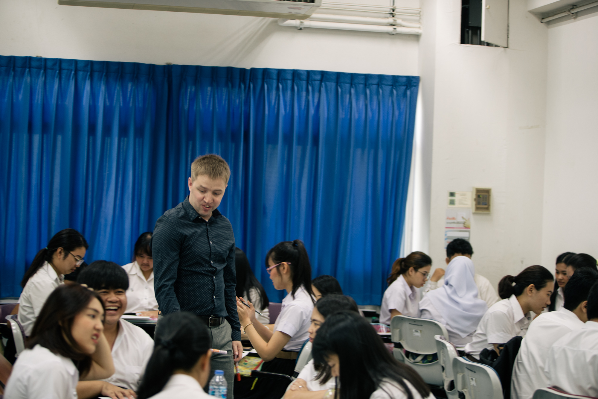 Kids sitting around table with the teacher helping out