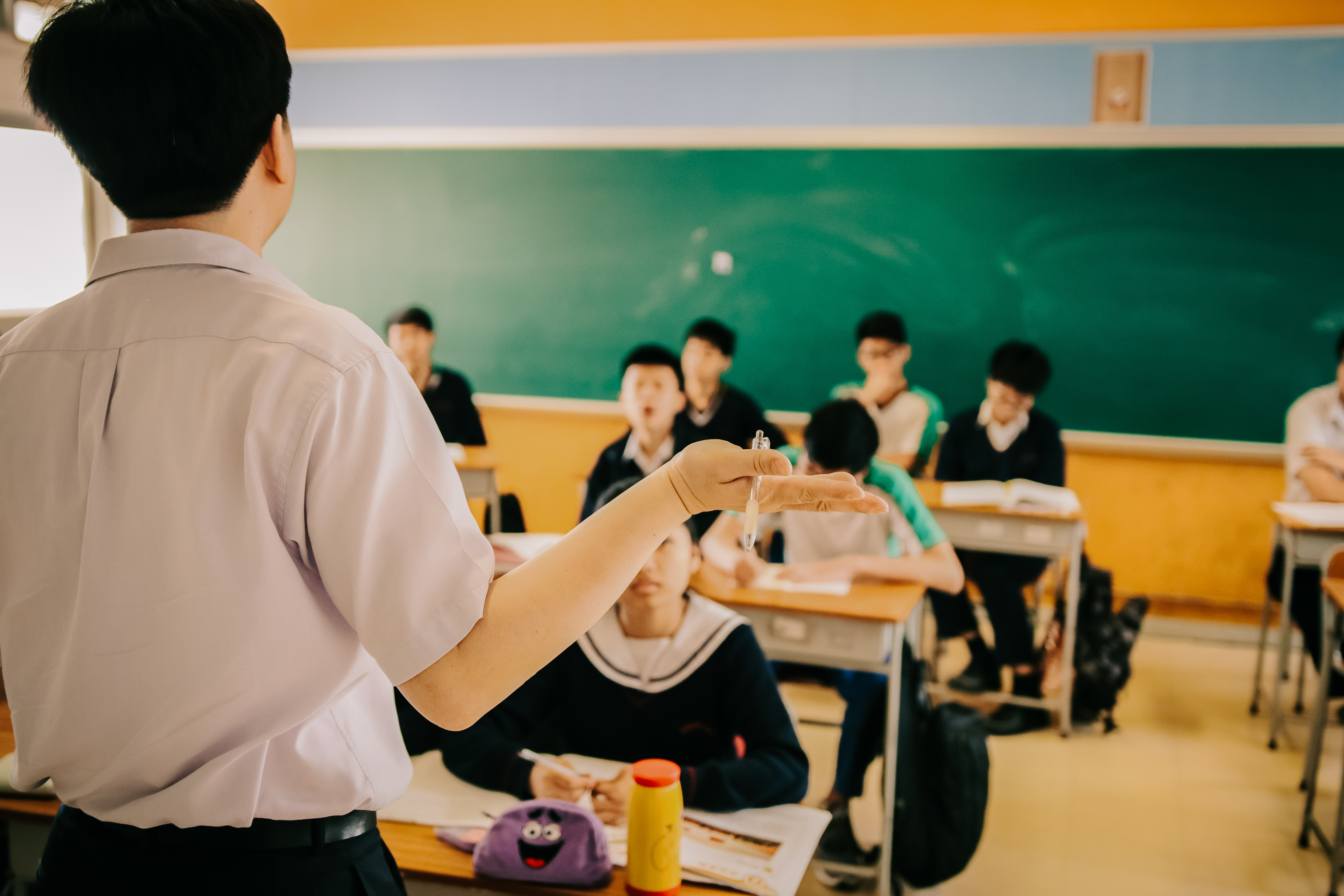 Photo of a group of students in a classroom with a teacher in the front.