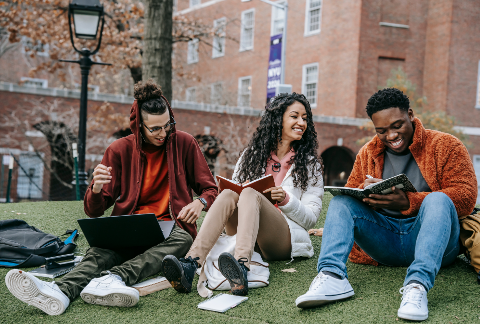 three students sitting together and laughing