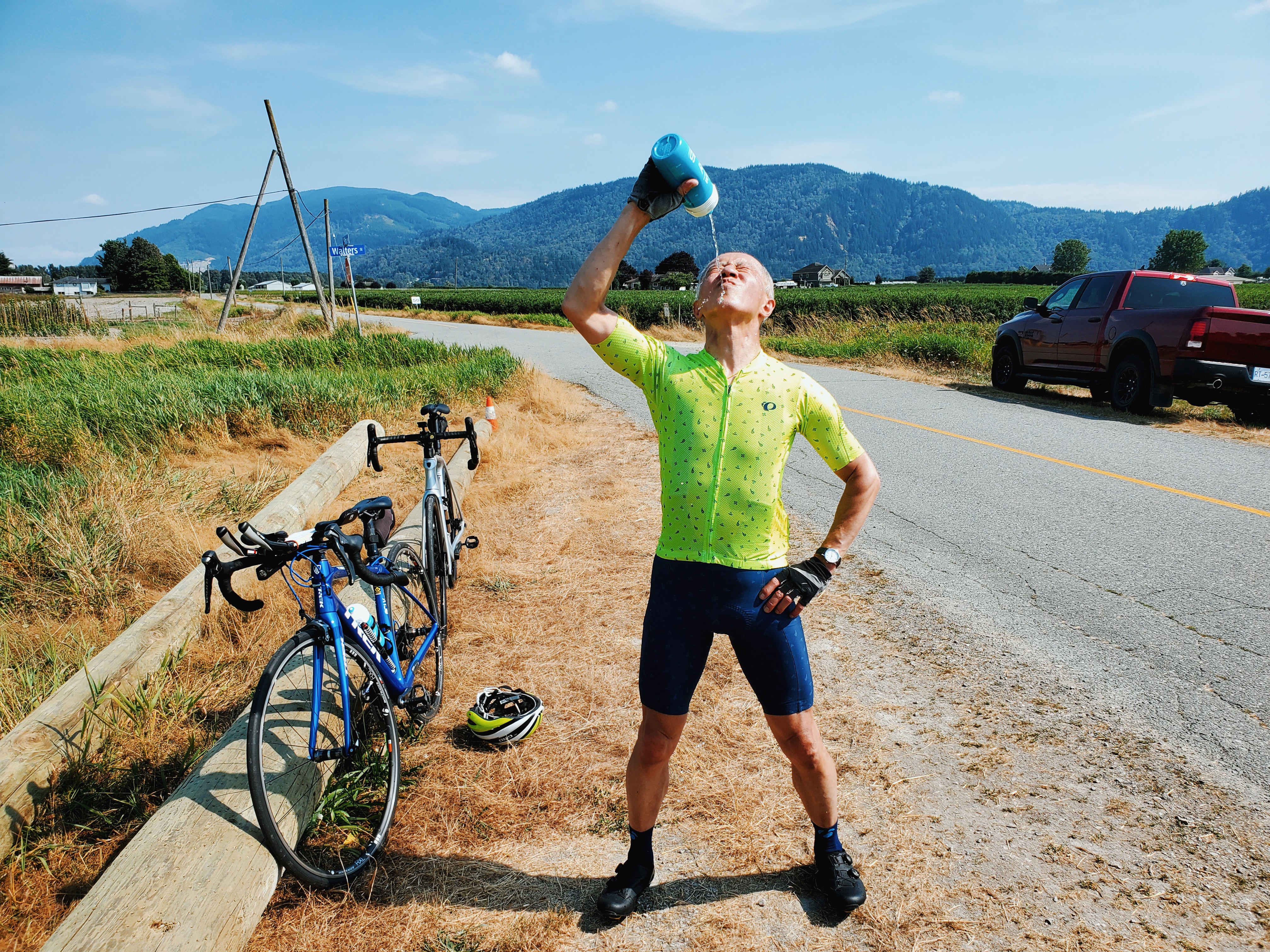 Cyclist squirting water on himself after biking