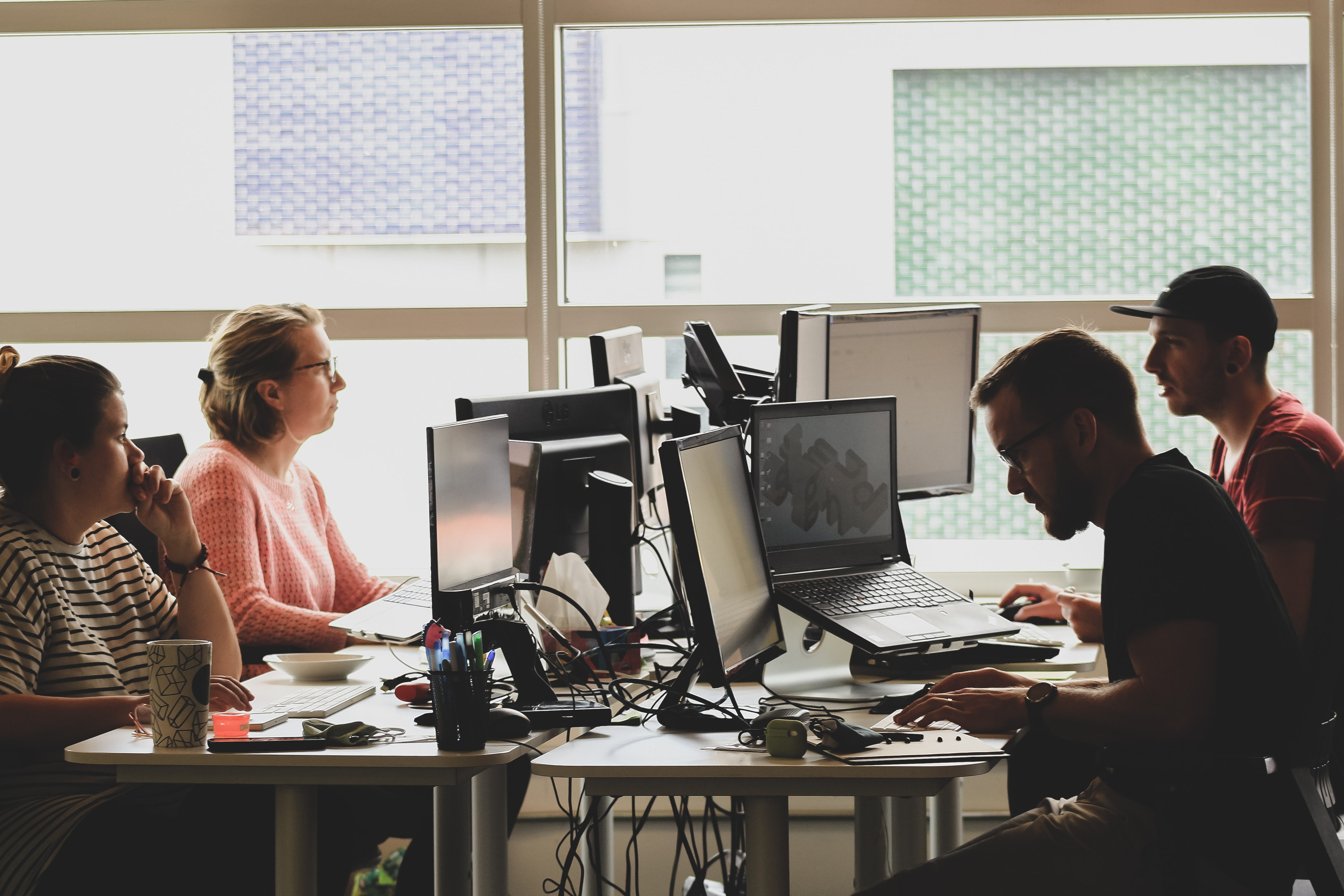 Photo by Sigmund on Unsplash of a group of people sitting in front of their computers.
