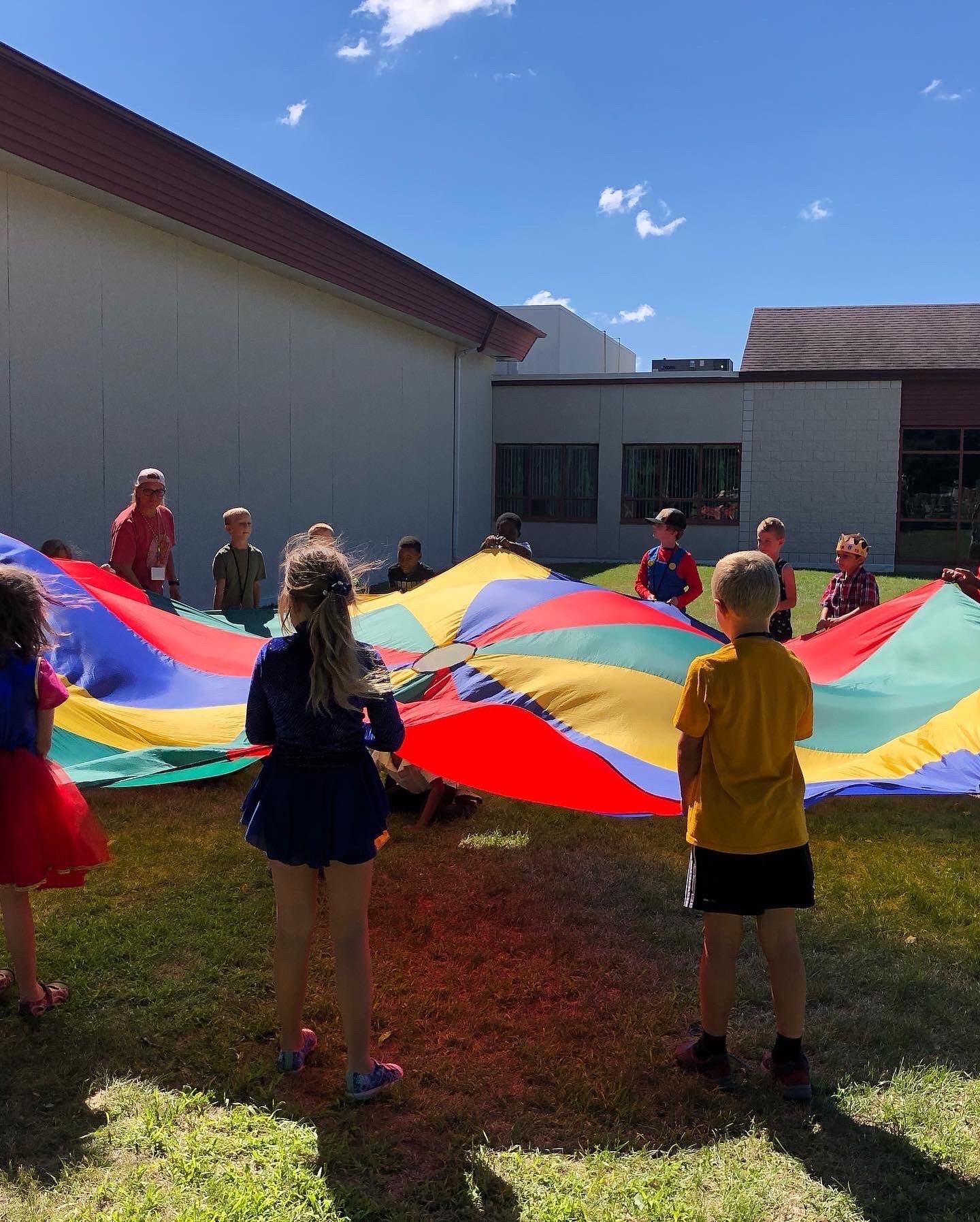 A group of children holding a parachute.