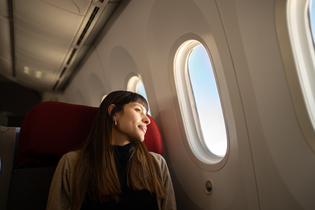 A woman looking out an airplane window.