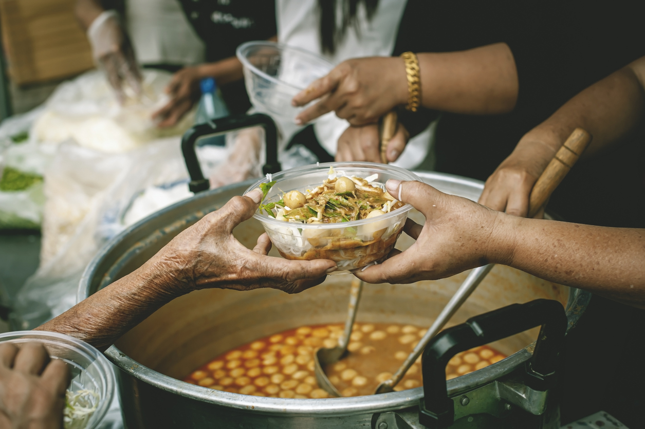 4 - Landing Page - Enrich - Not Just a Personal Pentecost - iStock-1837135303 A person being handed a bowl of food in a serving line.