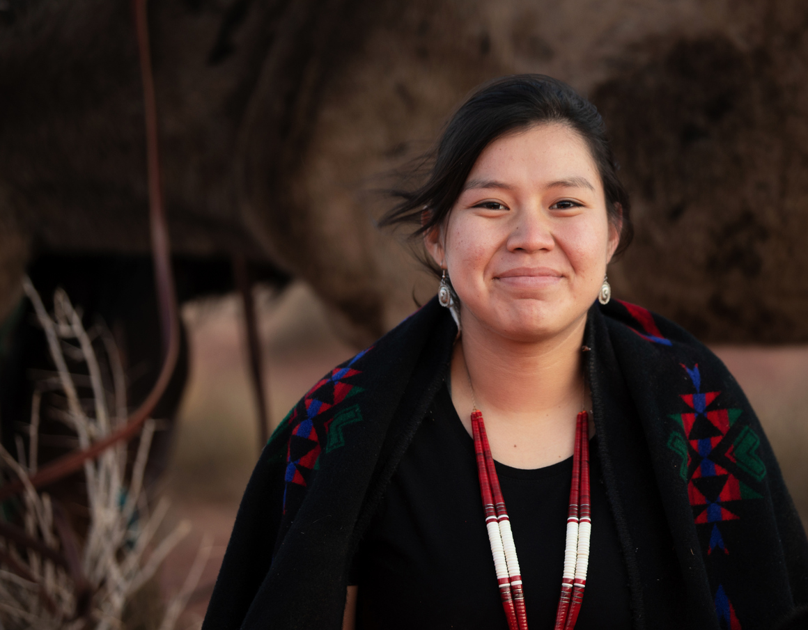 Cheerful Navajo young woman wearing traditional jewelry.