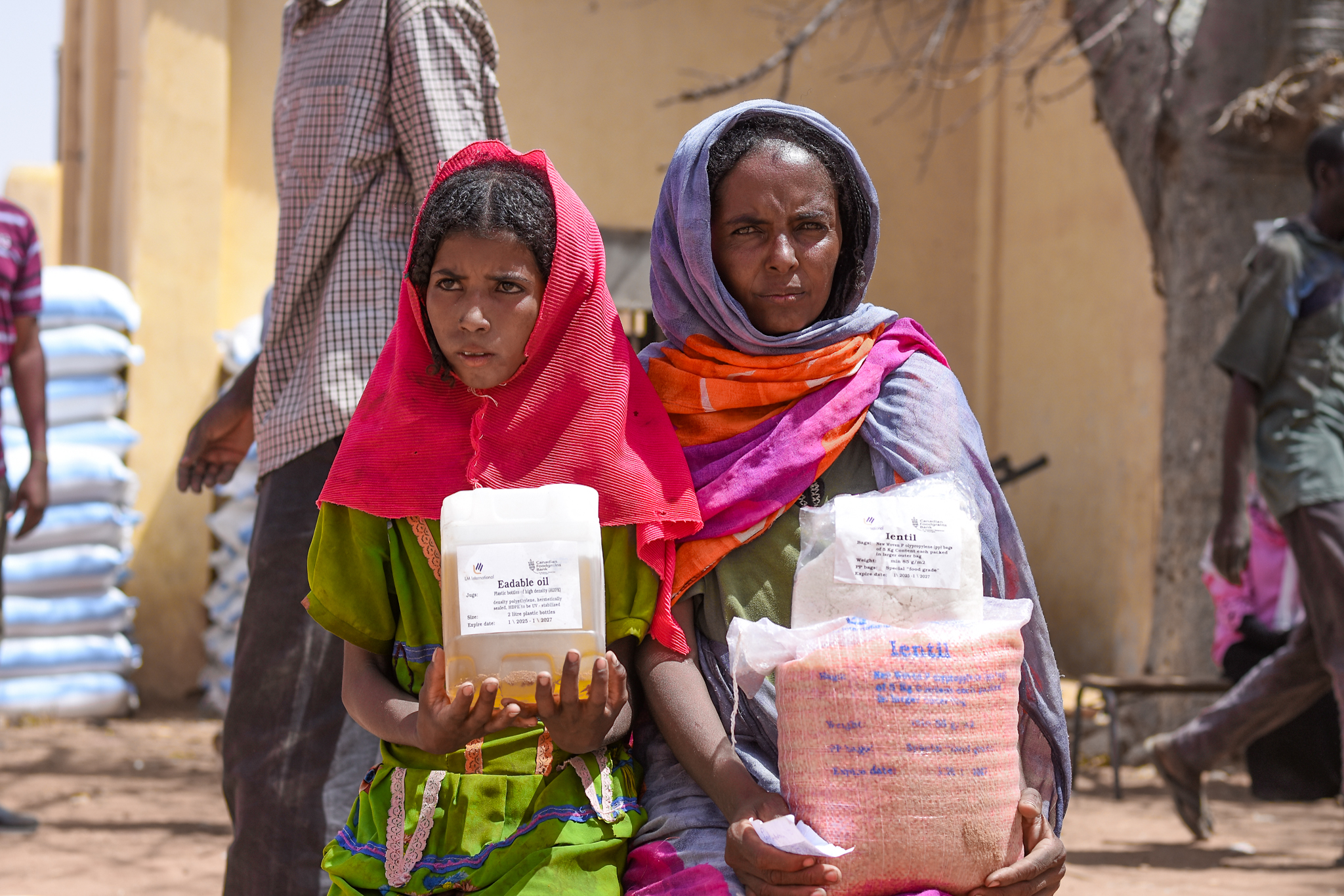 Two woman carrying food baskets.