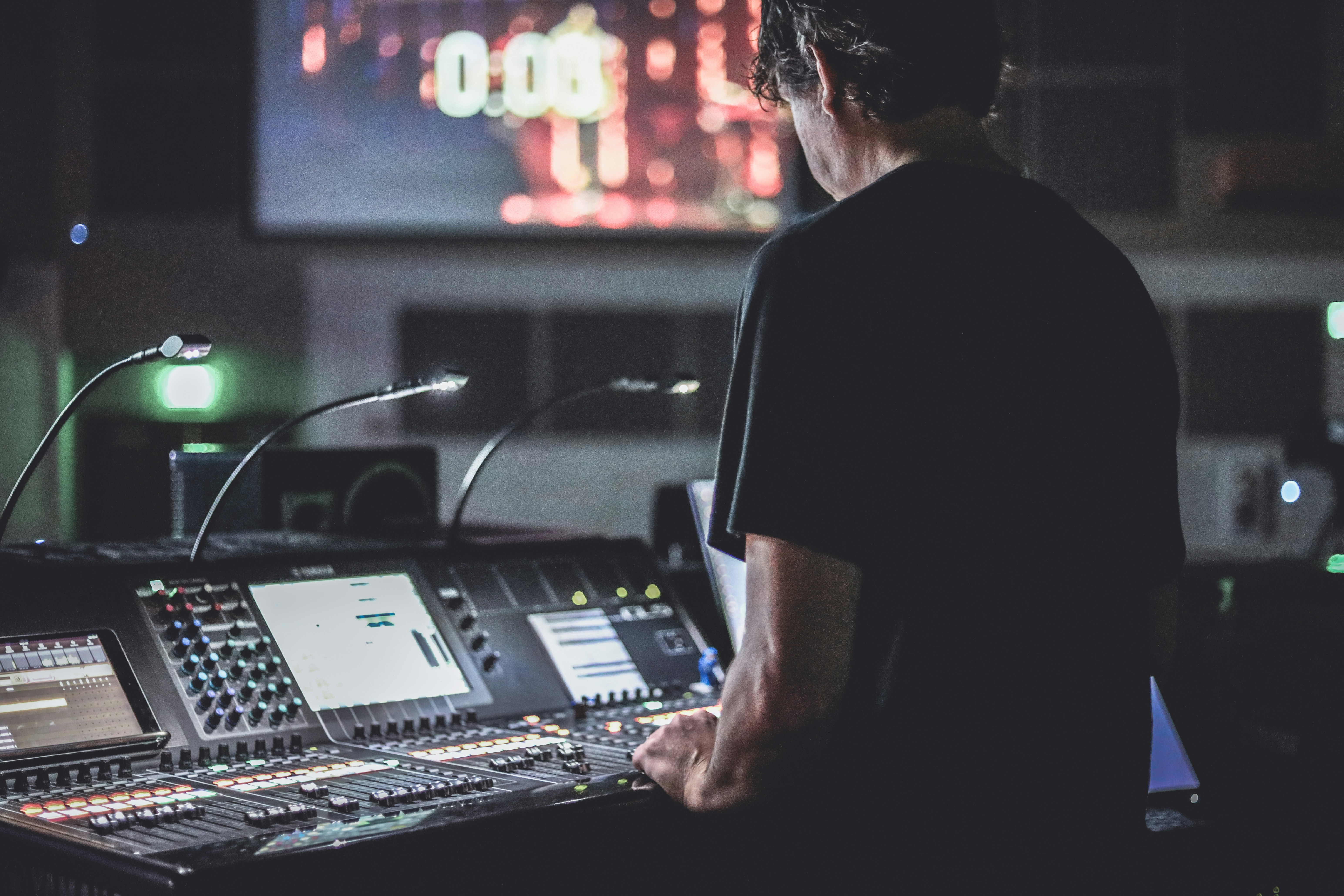 luis-morera-JHm1iz035Ks-unsplash Photo of a man standing in front of a soundboard.