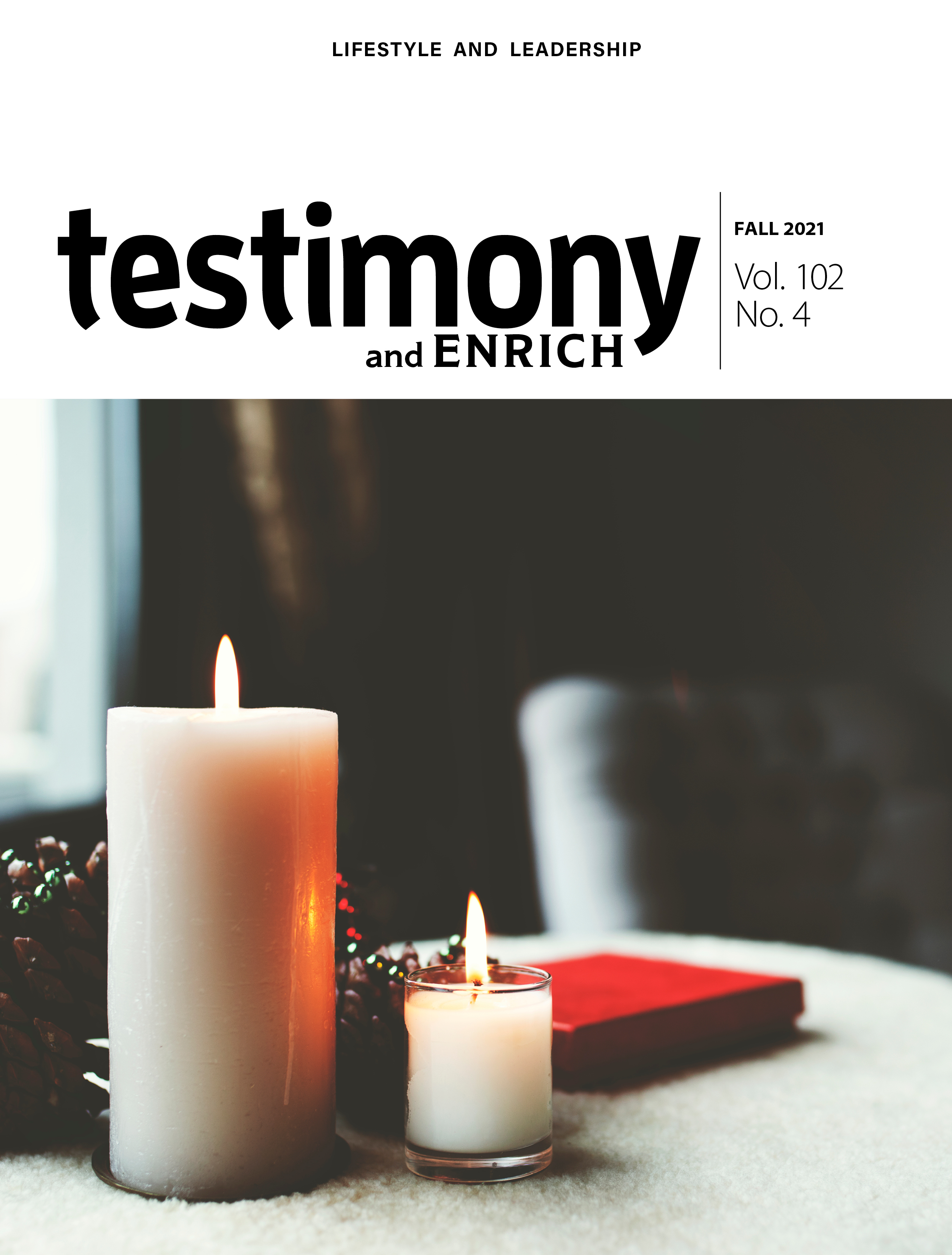 Cover of Fall 2021 testimony/Enrich - two candles burning on a table.